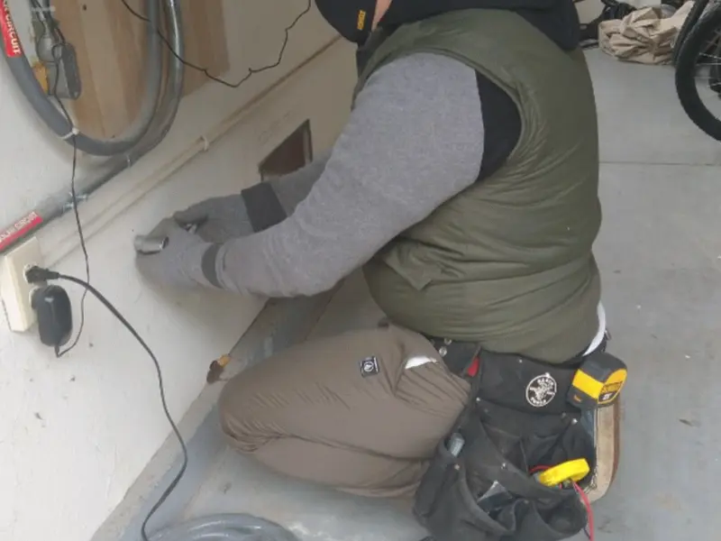 Electrician performing outlet wiring in a Palisades Park garage